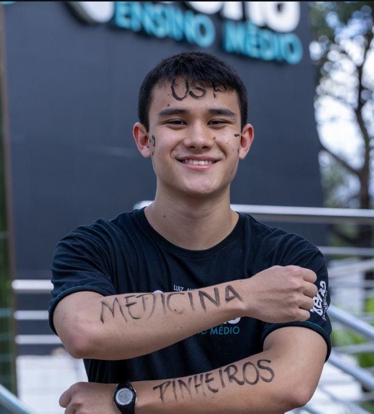 Luiz sorrindo, com USP escrito na testa e Medicina Pinheiros escrito nos braços